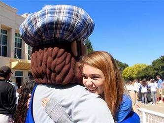 Monty hugging student